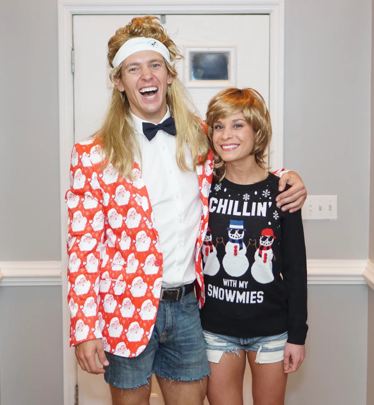 Couple at a Christmas party in mullet wigs and holiday outfits
