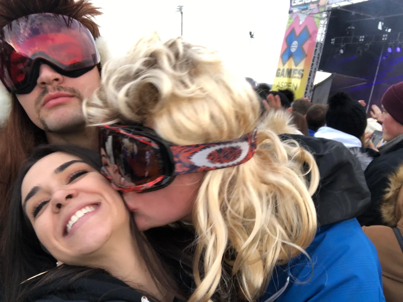 Friends in mullets and sunglasses piled together laughing