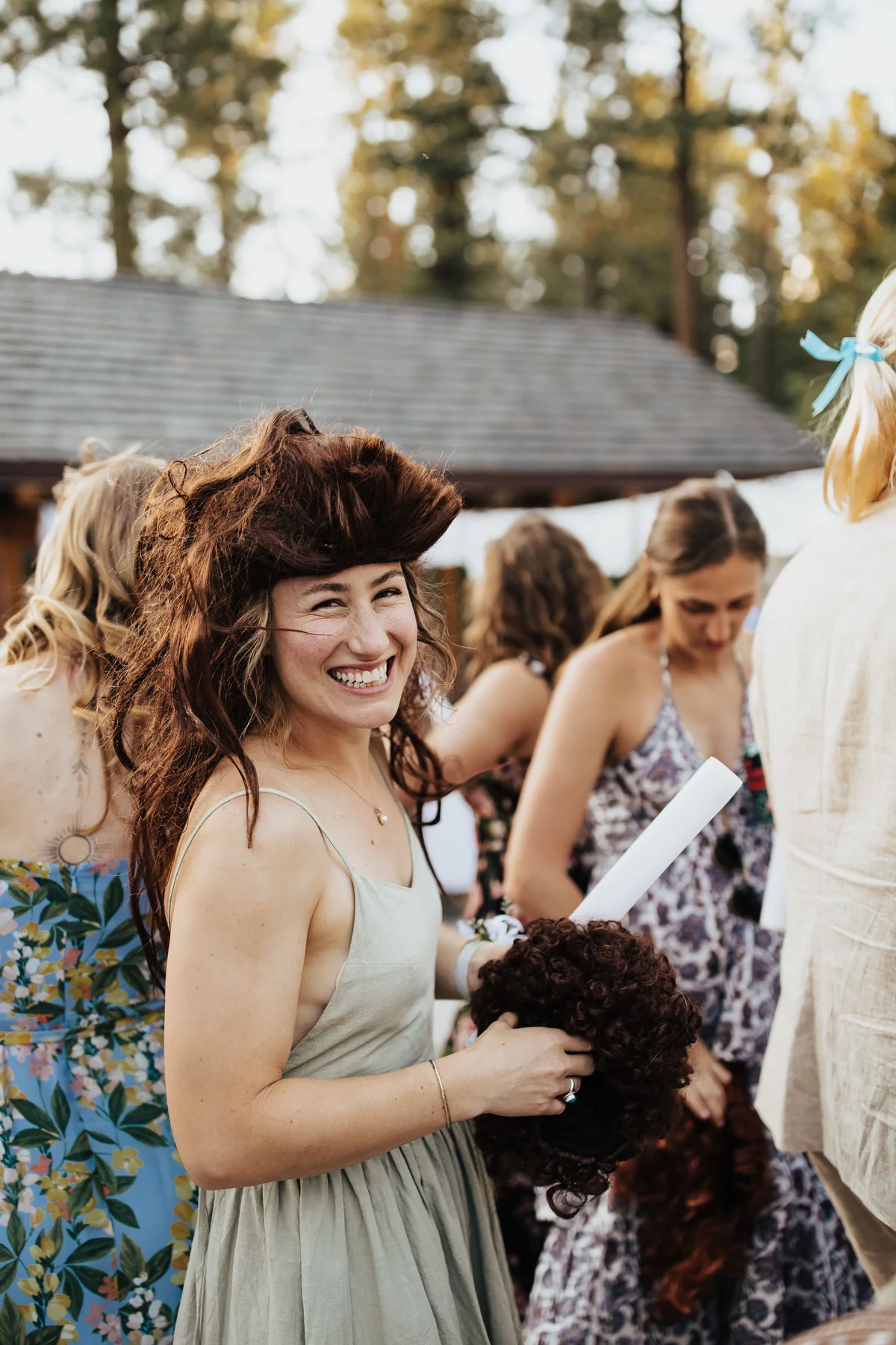 Bridesmaid in a brunette mullet laughing hard, the shot the photographer didn't plan for.