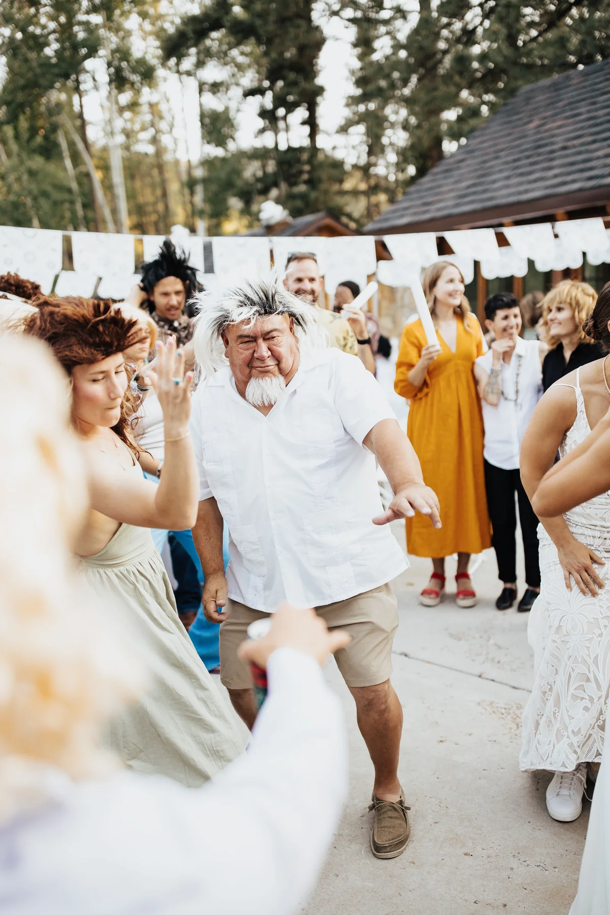 Grandpa with goatee in a salt-and-pepper mullet, dancing solo as guests cheer.