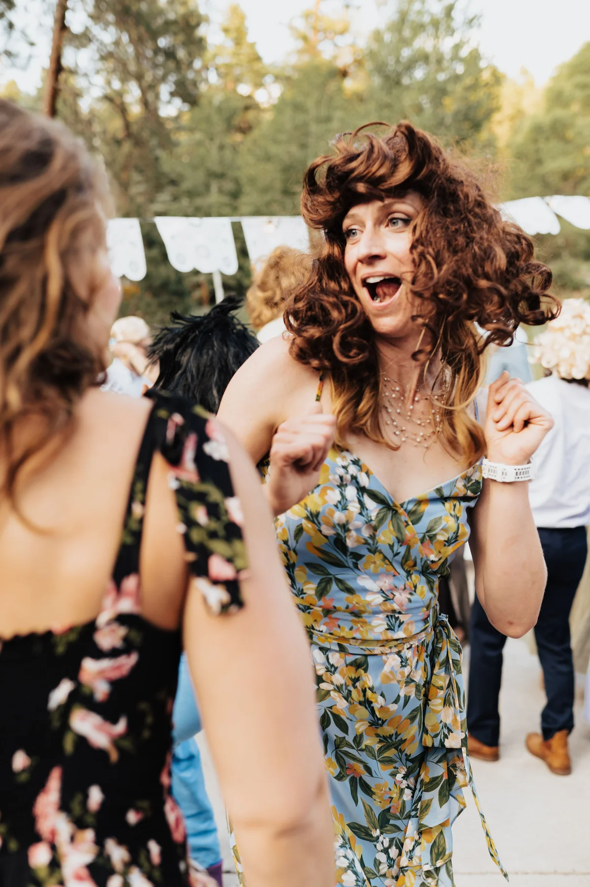 Guest in a curly auburn mullet mid-reaction, mouth wide open.