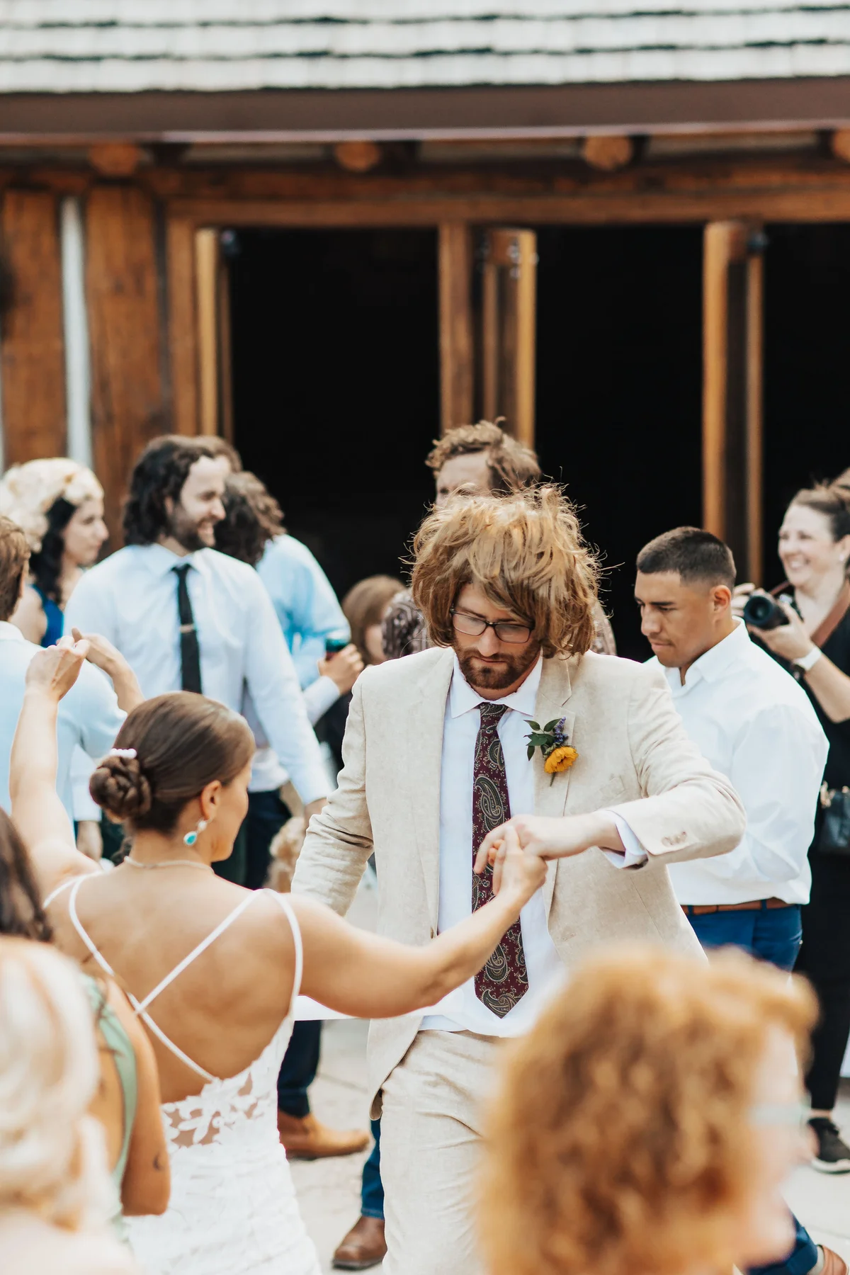Bride spinning with the groom mid-twirl, the groom now wearing a full sandy mullet.